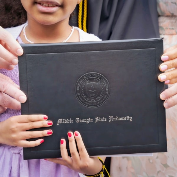 Parent and Child Holding Diploma at MGA Graduation