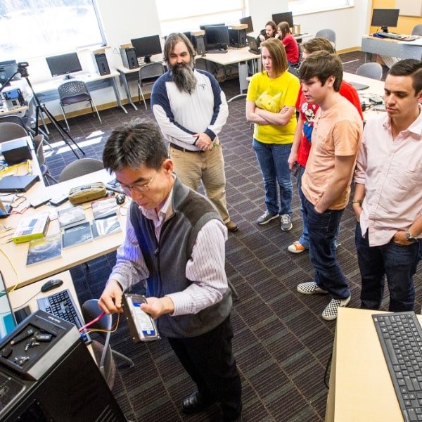 Professor Kwak demonstrating tech equipment set up to class