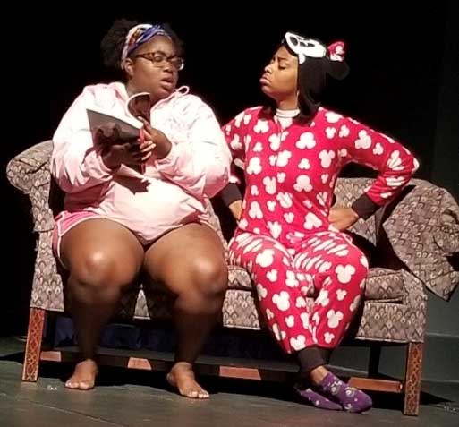 Students acting in a play while sitting on a couch