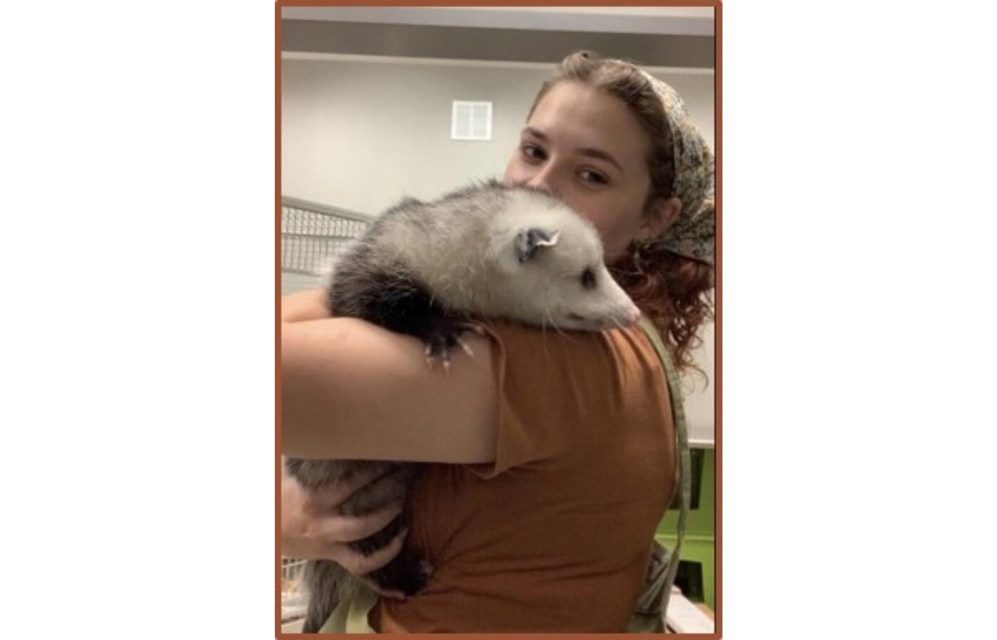 a student holding a possum over her shoulder