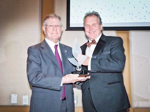 President Blake awarding Malcolm Burgess a flame award at a gala event