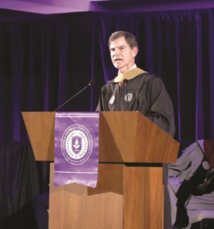 Don Avery in academic regalia, speaking during an MGA commencement ceremony