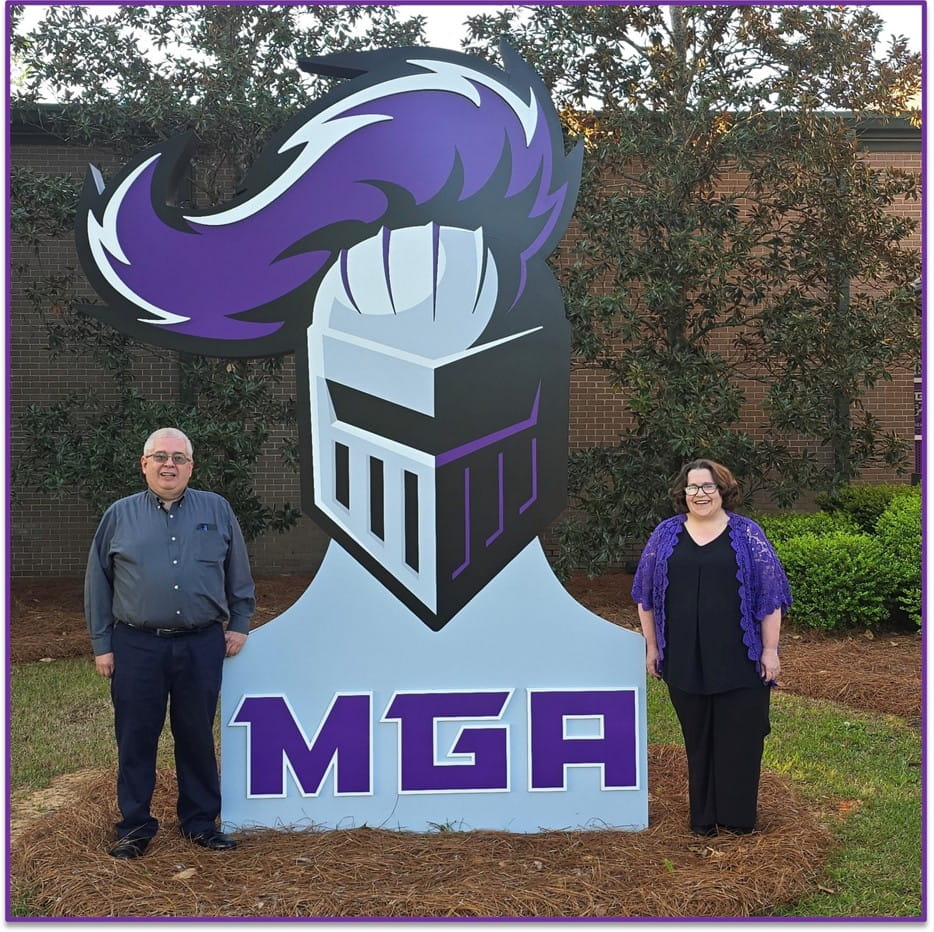 Dr. Stephen Svonavec and Dr. Kara Svonavec standing next to the Knight statue on the Cochran campus