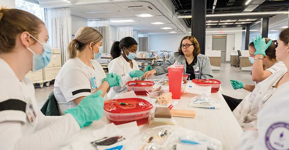A classroom using tupperwear of fake blood with tubes punctured to the lids.