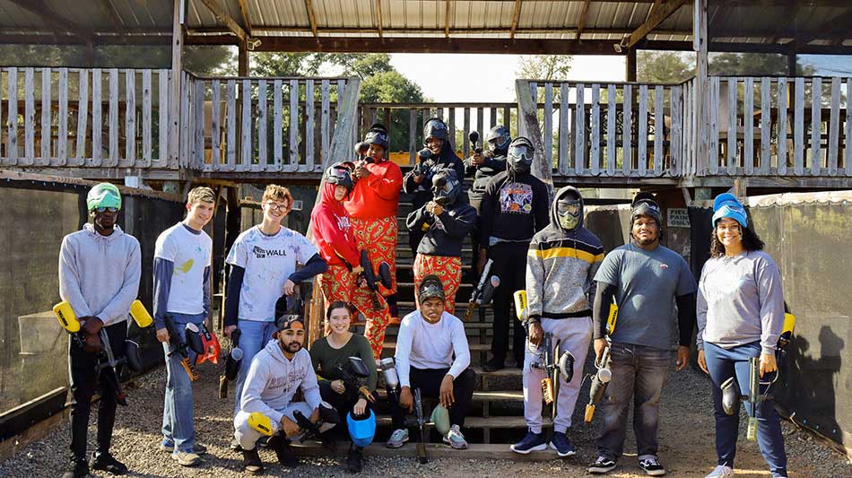 Students posing after a game of paintball.