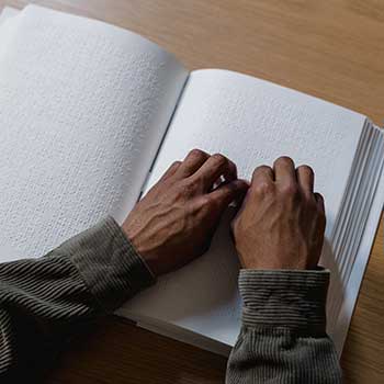 Photo of a person reading a book in Braille 