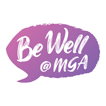 Photo of a colorful thought bubble that features the text Be Well at M G A within it