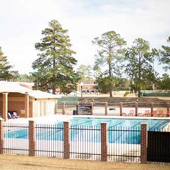 Photo of an outdoor swimming pool area with a fence around it
